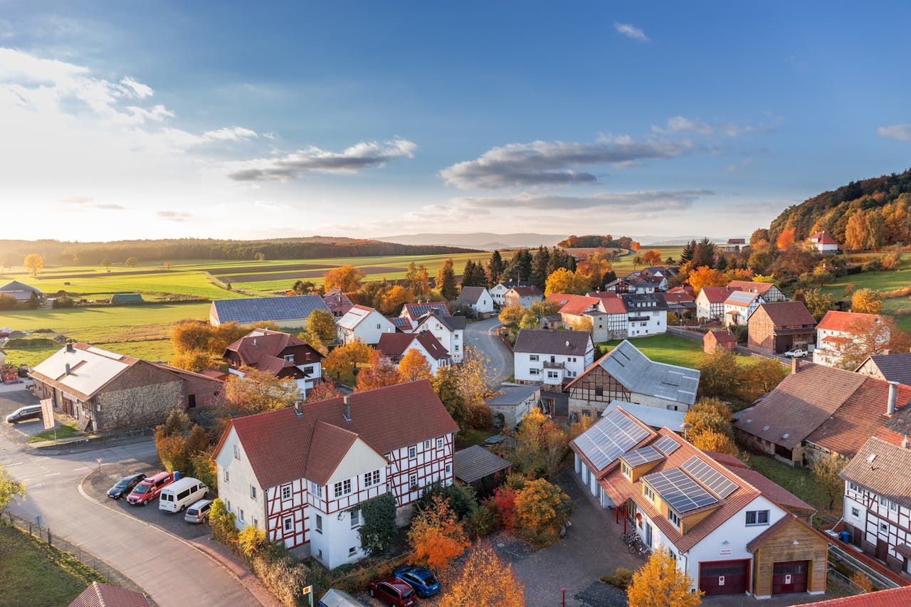 Services-03 Charming aerial view of a rural village in autumn with vivid colors and clear skies.