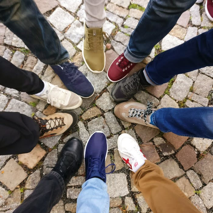 creative Circle of sneakers on cobblestone pavement representing diversity and urban fashion.